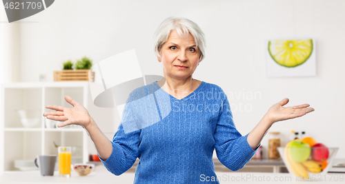 Image of senior woman having shrugging in kitchen