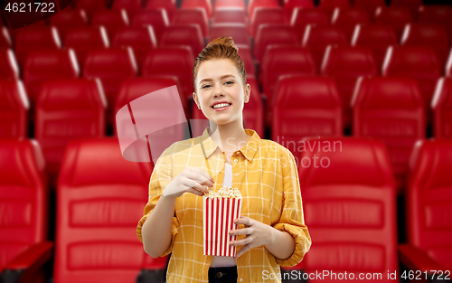 Image of redhead teenage girl with popcorn at movie theater