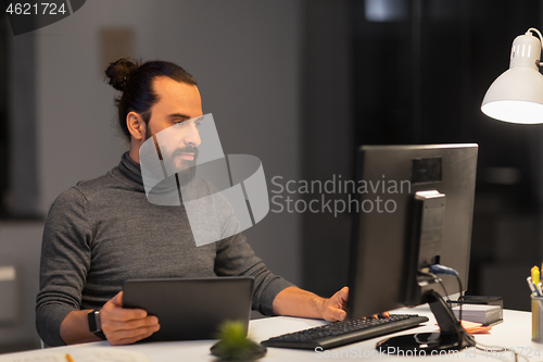 Image of creative man with computer working at night office