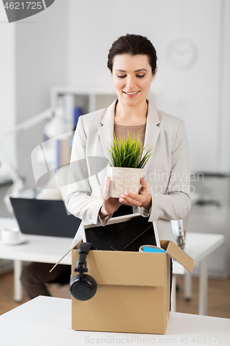 Image of happy businesswoman with personal stuff at office