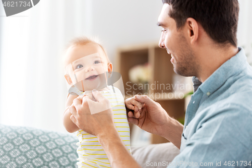 Image of father with little baby daughter at home