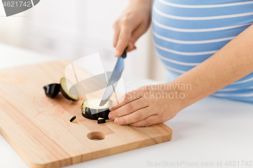 Image of close up of pregnant woman cooking food at home