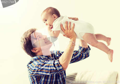 Image of happy young father playing with baby at home