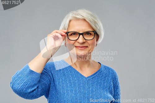 Image of portrait of senior woman in glasses over grey