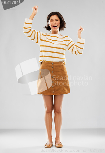 Image of young woman in striped pullover, skirt and shoes