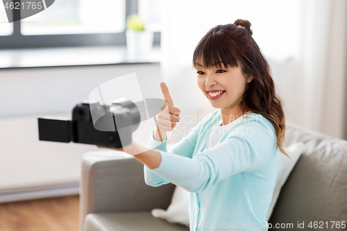 Image of asian female blogger with camera recording video