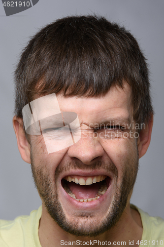 Image of Portrait of a man of European appearance, experiencing severe pain, close-up