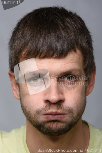 Image of Closeup portrait of a resentful man of European appearance who pouted his cheeks