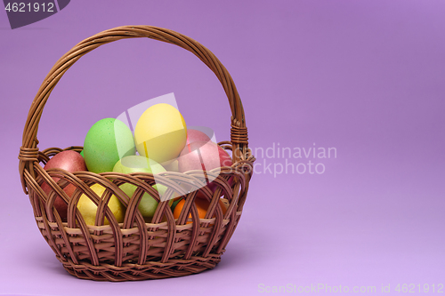 Image of Basket with easter eggs on a dark pink background