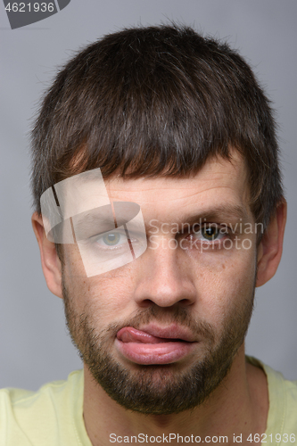 Image of Portrait of a sad man of European appearance with his tongue hanging out, close-up