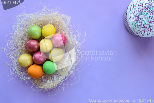 Image of Easter eggs on a purple background, next to Easter cake