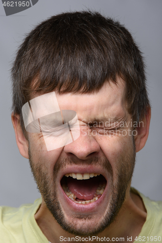 Image of Close-up portrait of a yawning man of European appearance with wide open mouth