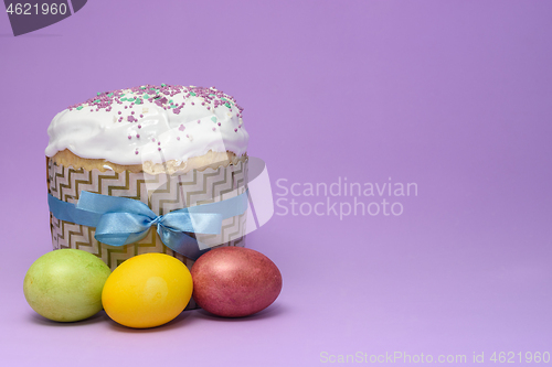 Image of Easter cake and three eggs on a dark pink background