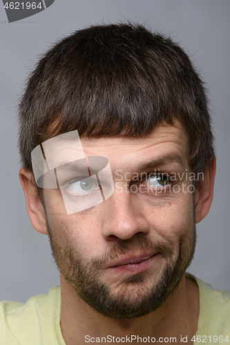 Image of Close-up portrait of a pensive man twisting his mouth, European appearance