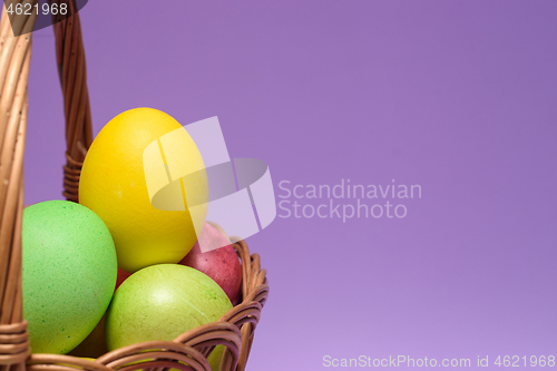 Image of Colored easter eggs in a basket, empty space on the right