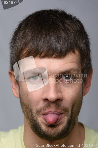 Image of Portrait of a man of European appearance showing tongue, close-up