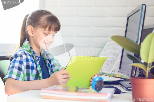 Image of Girl studying at school at home, watching a video lesson online