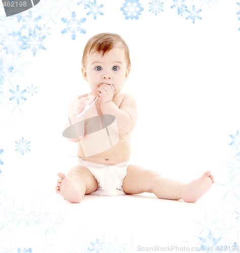 Image of baby boy in diaper with toothbrush