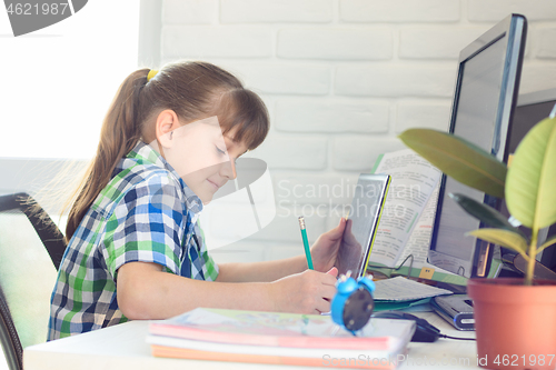 Image of Girl attends school remotely through online video tutorial