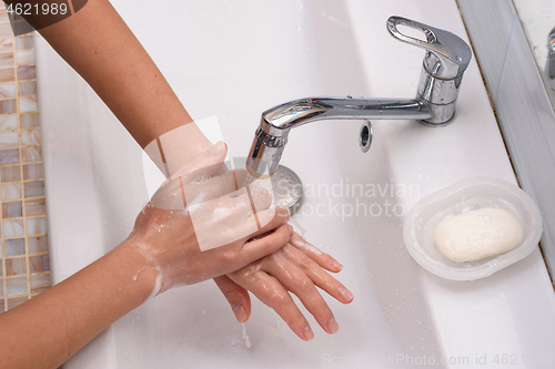 Image of Girl washes hands with soap, close up