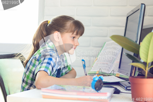 Image of Girl watching a video lesson at home on distance learning