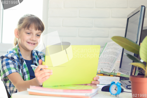 Image of A ten year old girl happily looks at the screen of a tablet computer