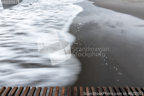 Image of Wave rolls ashore, long exposure black and white photography