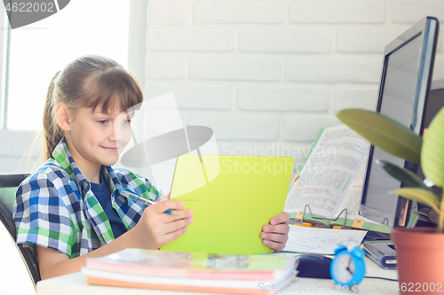 Image of Girl watching video tutorials on a tablet while at home