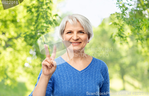 Image of portrait of smiling senior woman showing peace