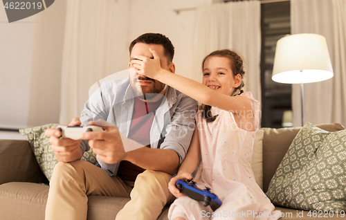 Image of father and daughter playing video game at home