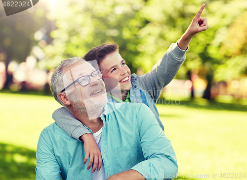 Image of grandfather and boy pointing finger at summer park