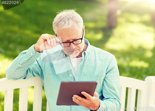 Image of senior man with tablet pc at summer park