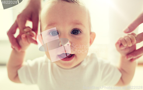 Image of happy baby learning to walk with mother help