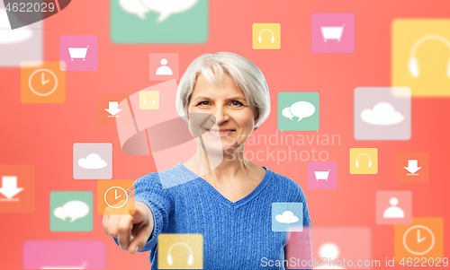 Image of senior woman pointing to mobile app clock icon