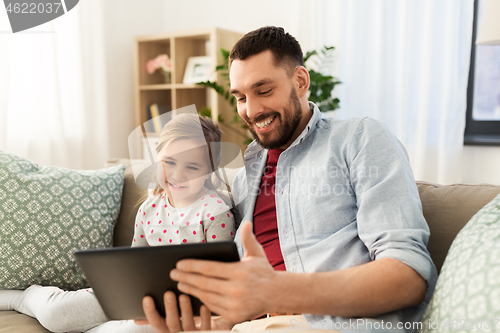 Image of father and daughter with tablet computer at home