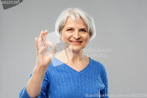 Image of portrait of smiling senior woman making ok gesture