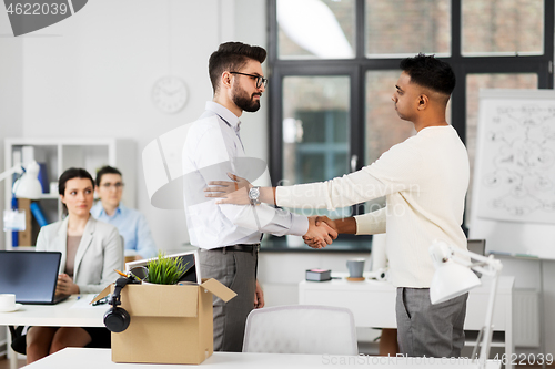 Image of colleague seeing off sad fired male office worker