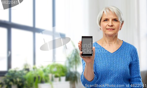 Image of senior woman showing smartphone at home