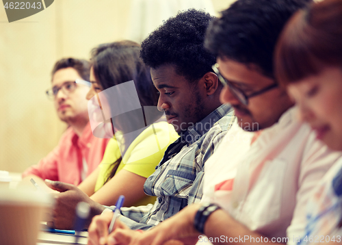 Image of group of international students writing at lecture