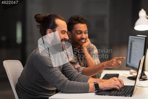 Image of creative team with computer working late at office