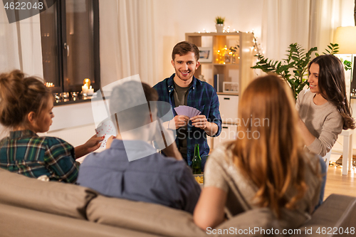 Image of friends playing cards and drinking beer at home