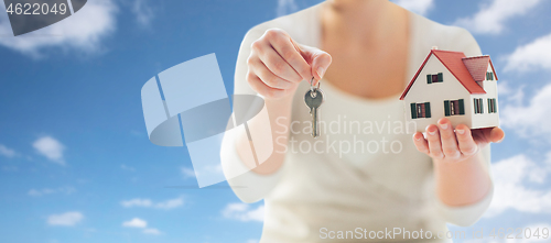 Image of close up of hands holding house model and keys