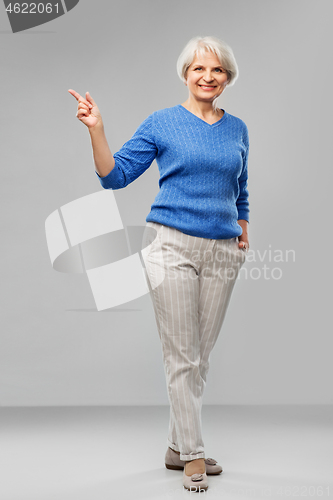 Image of portrait of smiling senior woman in blue sweater