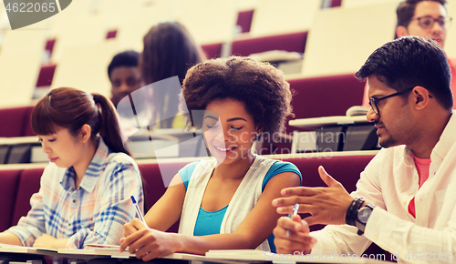 Image of group of students with notebooks in lecture hall