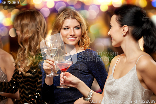 Image of happy women clinking glasses at night club