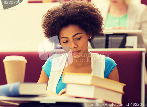 Image of student girl with books and coffee on lecture