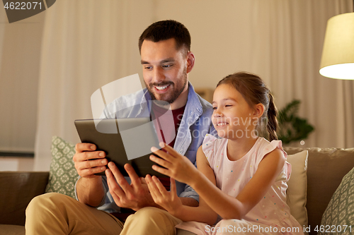 Image of father and daughter with tablet computer at home