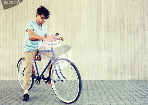 Image of man with smartphone and fixed gear bike on street