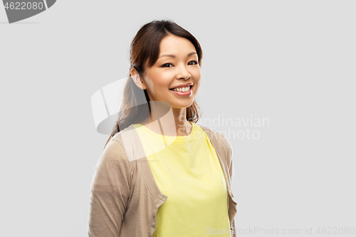 Image of happy asian woman over grey background