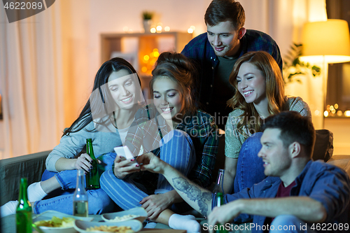 Image of friends with smartphone watching tv at home